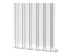 a blue and white striped wallpaper with vertical stripes on the bottom half of it