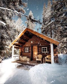 a cabin in the woods with snow on the ground