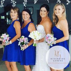 four bridesmaids in blue dresses posing for a photo with their bridal bouquets