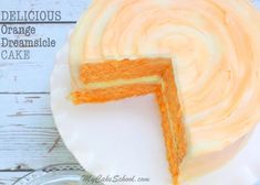 a cake with orange icing on a plate next to a slice missing from it