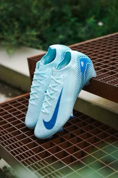 a pair of blue and white shoes sitting on top of a metal grate