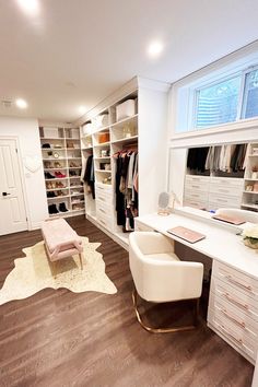 an organized closet is shown with white furniture and open shelving units, along with a large rug that matches the hardwood flooring