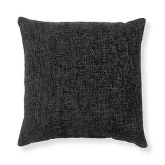 a black pillow that is on a white surface and it has a dark textured fabric