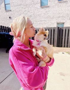 a woman holding a small dog in her arms