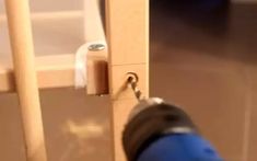 a close up of a person opening a door with a screwdriver on it