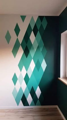 an empty room with green and white geometric wallpaper on the walls, in front of a window