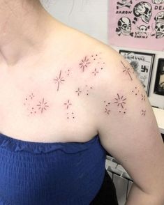 a woman wearing a blue top with stars on her chest and arm tattooing it