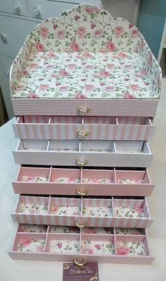 three pink and white boxes stacked on top of each other, with floral designs in them