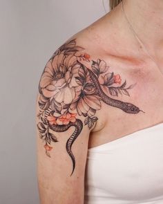 a woman with a snake and flowers tattoo on her shoulder