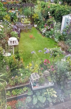 an aerial view of a garden with lots of flowers and plants in the foreground