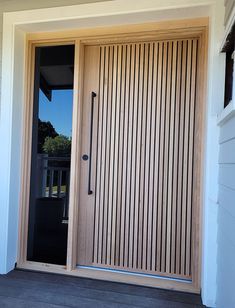 the front door to a house with wooden slats