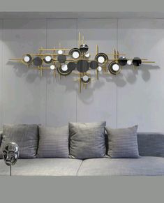 a living room with a gray couch and lots of mirrors on the wall above it