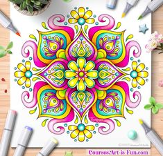 a coloring book with colorful designs on the cover and markers next to it, surrounded by flowers