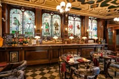 an old fashioned bar with stained glass windows and checkered flooring on the walls