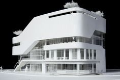 an architectural model of a white building with trees on top