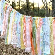 a bunch of colorful ribbons hanging from a fence