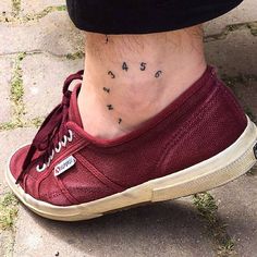 a woman's foot with tattoos on her ankle and the word love is written in small cursive letters