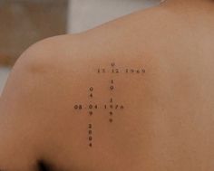 the back of a woman's shoulder with numbers written on it in black ink