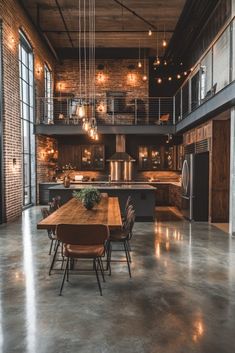 an industrial style kitchen and dining room with exposed brick walls, large windows, stainless steel appliances and wooden table