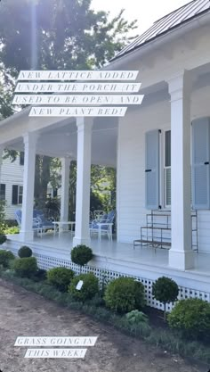 the front porch of a white house with blue shutters on it's sides