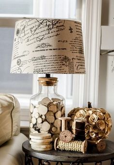 a lamp that is sitting on top of a table next to a vase with coins in it