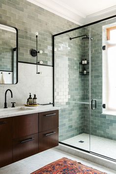 a bathroom with a sink, mirror and shower stall in front of a large window