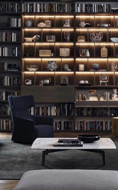 a living room filled with lots of furniture and bookshelves covered in shelves next to a coffee table