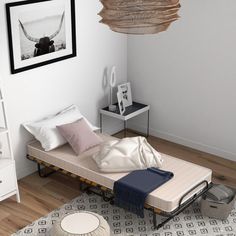 a bed sitting on top of a wooden floor next to a white wall