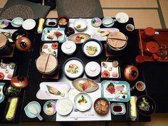 an overhead view of a table with many plates and bowls on it, including sushi