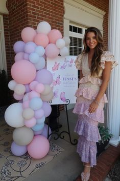 a woman standing next to a bunch of balloons