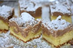 several pieces of cake sitting on top of a metal pan covered in powdered sugar