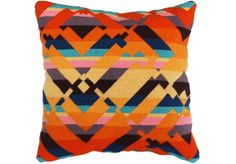 an orange and blue pillow with multicolored squares on it's back side