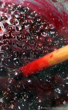 a wooden stick sticking out of a pot filled with black and red liquid or water