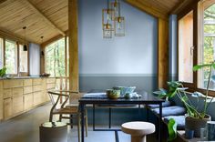 a dining room table and chairs in front of large windows with wooden beams on the ceiling