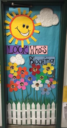 a door decorated with flowers and the words look who's blooming