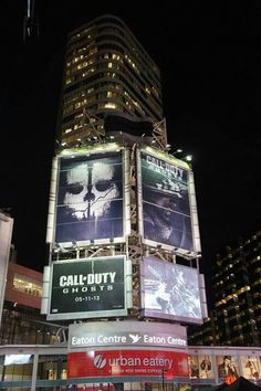 a large building with many billboards on it's sides in the city at night