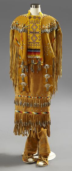 Apache Girl's Ceremonial Two Piece Puberty Dress, 20th c., composed of beaded hide with long fringe, with steel studs and tin cones, consisting of a top and skirt, along with a beaded cravat, Top- H.- 30 in., Skirt- H.- 33 in. American Indian Clothing, Native Regalia, Apache Indian, Native American Regalia, Native Dress, Native American Clothing, Pattern Dress Women, Native American Artifacts