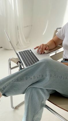 a woman sitting in a chair using a laptop computer