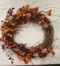 a wreath made out of branches and orange berries