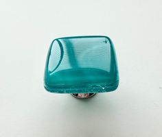 a green glass knob on a white surface