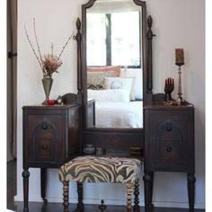 a bedroom with a zebra print foot stool and dresser in front of a large mirror