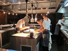 three men are in the kitchen preparing food