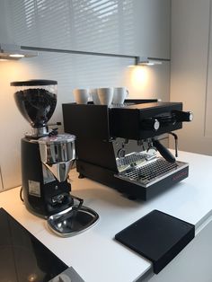 an espresso machine sitting on top of a counter next to a coffee maker