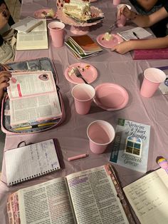 several people sitting at a table with books and drinks