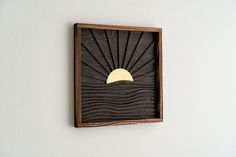 a wooden wall hanging with a sun and waves on it