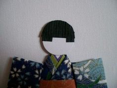 an image of a doll made out of japanese fabric material on a white wall background