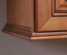 a close up view of the corner of a cabinet with woodgrain on it