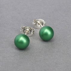 This small pair of emerald green pearl studs has been created using 6mm eden green Swarovski pearls. As they arrive individually gift wrapped in the black box pictured, these grass green stud earrings make perfect gifts.  All of the fittings used are Sterling silver. These round glass pearl earrings are sold with butterfly backs to ensure they stay securely in place. Your everyday jewellery will arrive gift wrapped and ready to present as a gift or to enjoy as a treat to yourself. All of my items are securely packaged to ensure they arrive in perfect condition.  Other colours available: https://www.etsy.com/shop/annakingjewellery/search?search_query=pearl+studs&order=date_desc&view_type=list&ref=shop_search ----------------------- Shipping estimates ------------------------- United Kingdom Chunky Stone Necklace, Eden Green, Green Stud Earrings, Green Jewellery, Round Pearl Earrings, Fused Glass Necklace, Jewelry King, Green Pearls, Green Jewelry