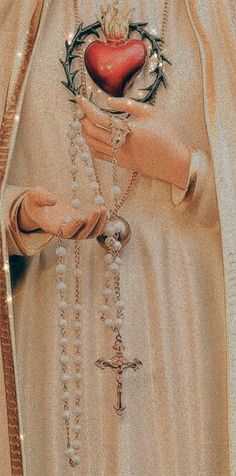 an image of a woman holding a rosary and heart in her hands with the cross on it