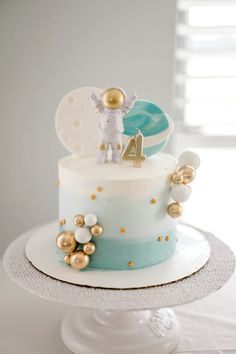 a white and blue cake with gold decorations